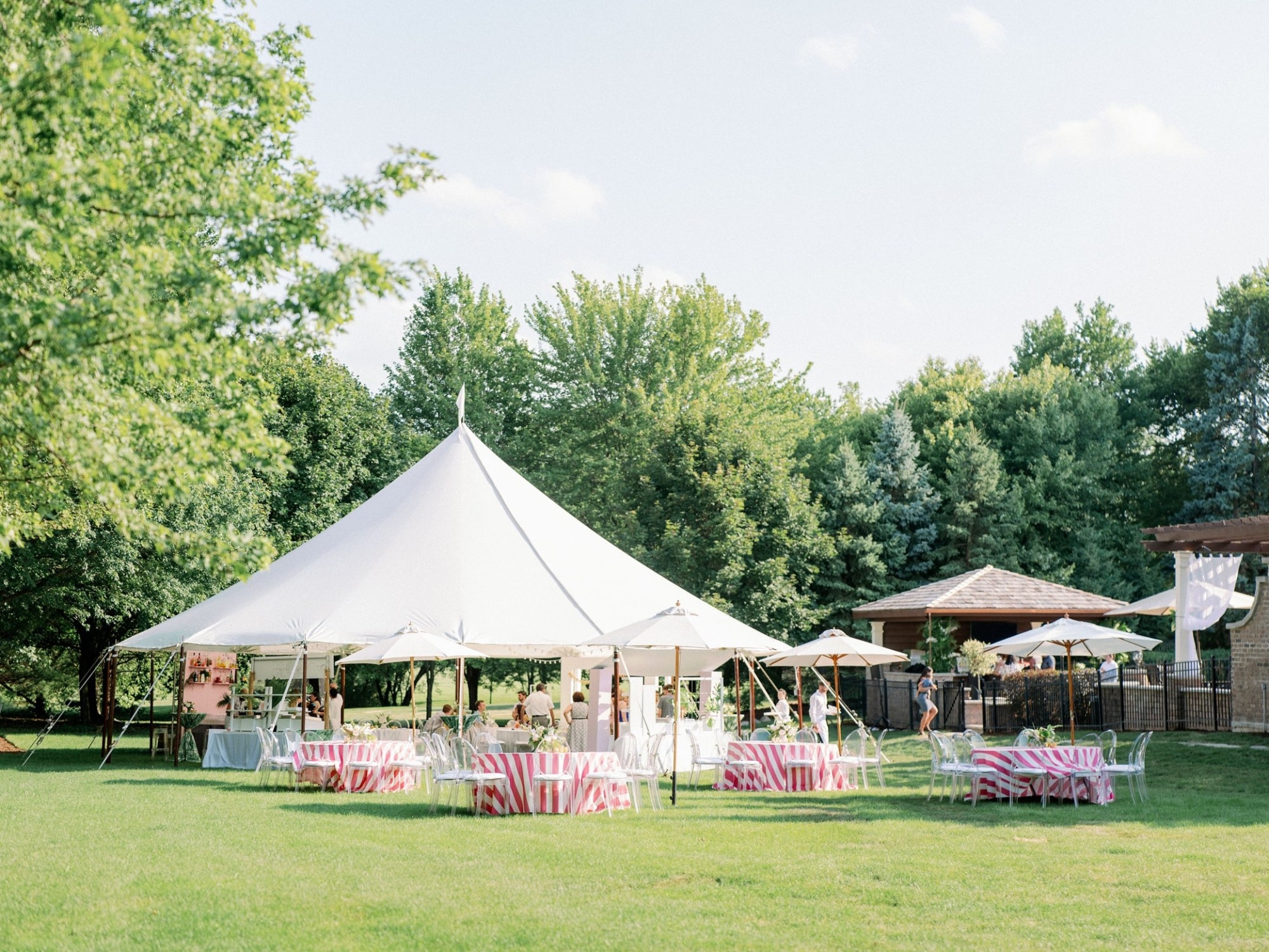 an outdoor summer event catering photo with white tents in a park on a lawn