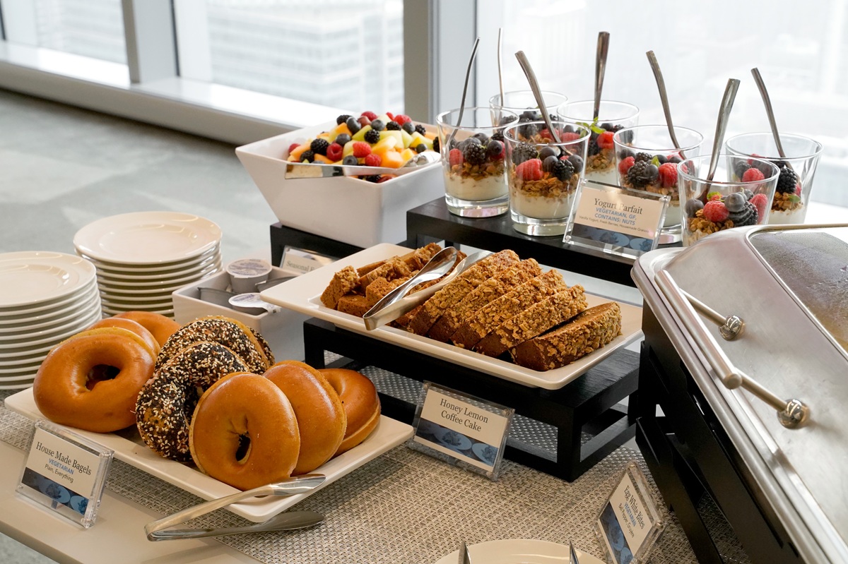 high end dorporate office lunch catering with bagels, bread slices, fruit parfait cups, and salads